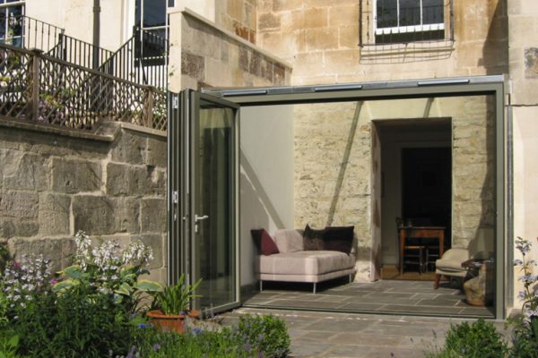 External image of the exterior of a contemporary conservatory extension to a Georgian house in Bath, showing the glass bi-fold doors and seamless transition from the house to the courtyard garden.