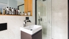 interior photograph of the modern bathrooms, with black taps and shower fittings it contrast again the neutral palette of tiles on the walls and floor. 