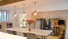 Image of dining table in contemporary kitchen dining room with old fireplace behind displaying wine bottles