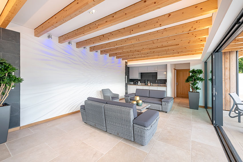 image of the enclosed sitting and socializing area with an open plan kitchen and exposed timber rafters above