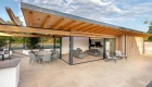Perspective view of the poolside building with exposed timber structure and blue sky