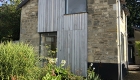 Image of a contemporary split level bungalow gable end with natural stone and vertical timber cladding