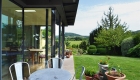 metal table and chairs in front of contemporary extension with view to Bathford hills beyond