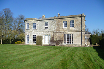 Exterior image of manor house grand stone elevation with curved bay
